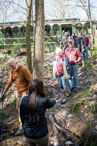 Riders are hiking down a trail to a local waterfall during the Waterfall Trolley Tour with help from Jennifer Long-Dillon.