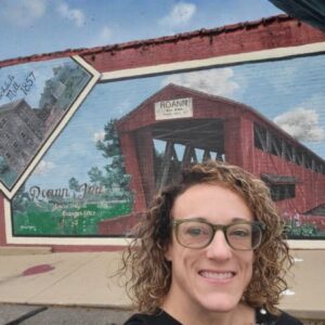 Picture of Stephanie Rogers standing infront of a mural